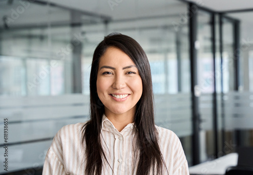 Obraz na plátně Confident smiling young professional Asian business woman corporate leader, happy japanese female employee, company sales marketing manager, standing in office, headshot portrait
