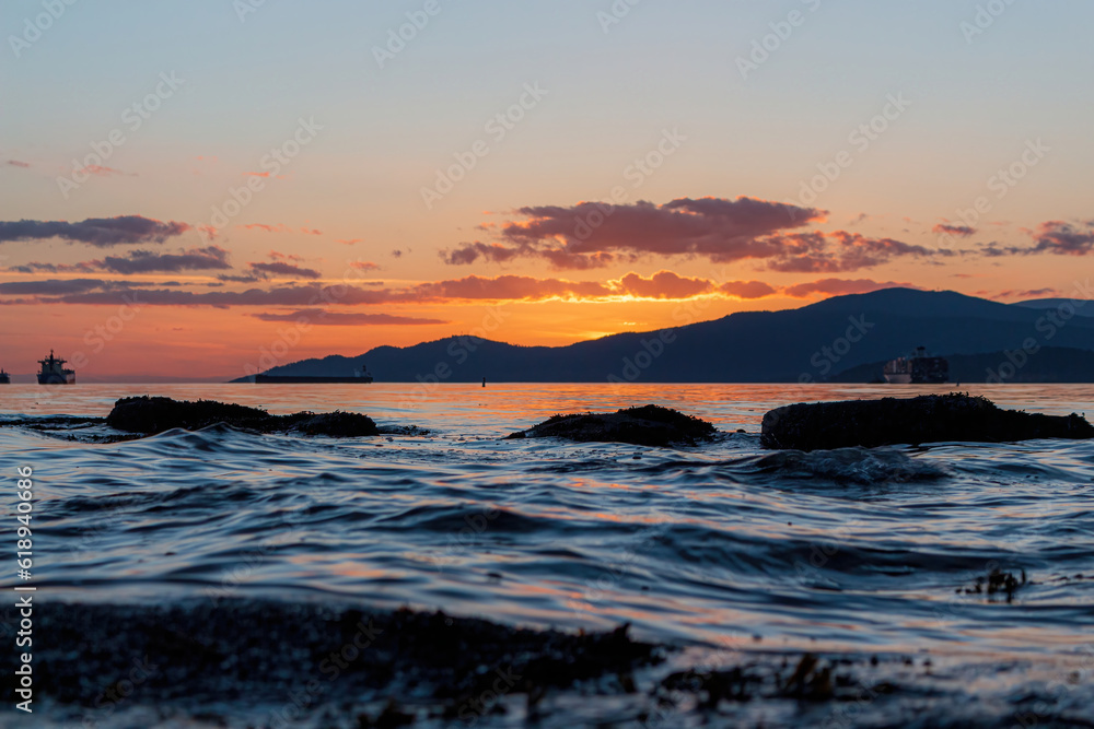 Dramatic sunset over mountains with ocean water in the front
