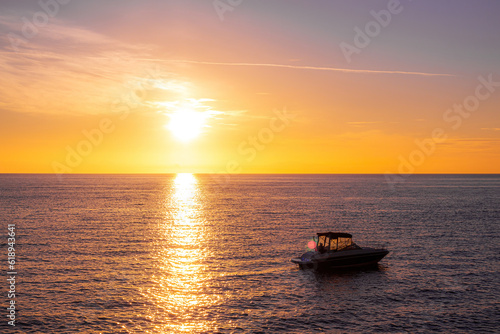Orange sunset with ocean and a boat