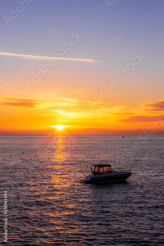 Orange sunset with ocean and a boat