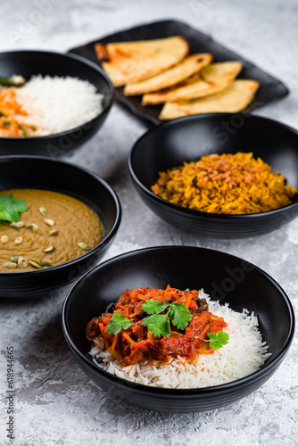 Set of Asian food: rice with stew and vegetables, lentil soup puree and Naan flatbread, lunch menu.