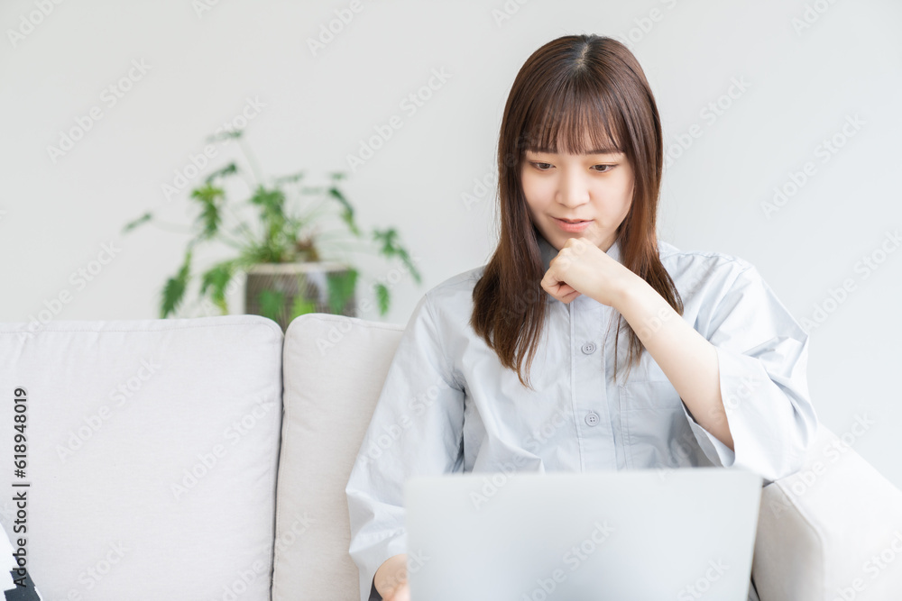 部屋でラップトップコンピューターを見る女性 部屋でラップトップコンピューターを見る女性