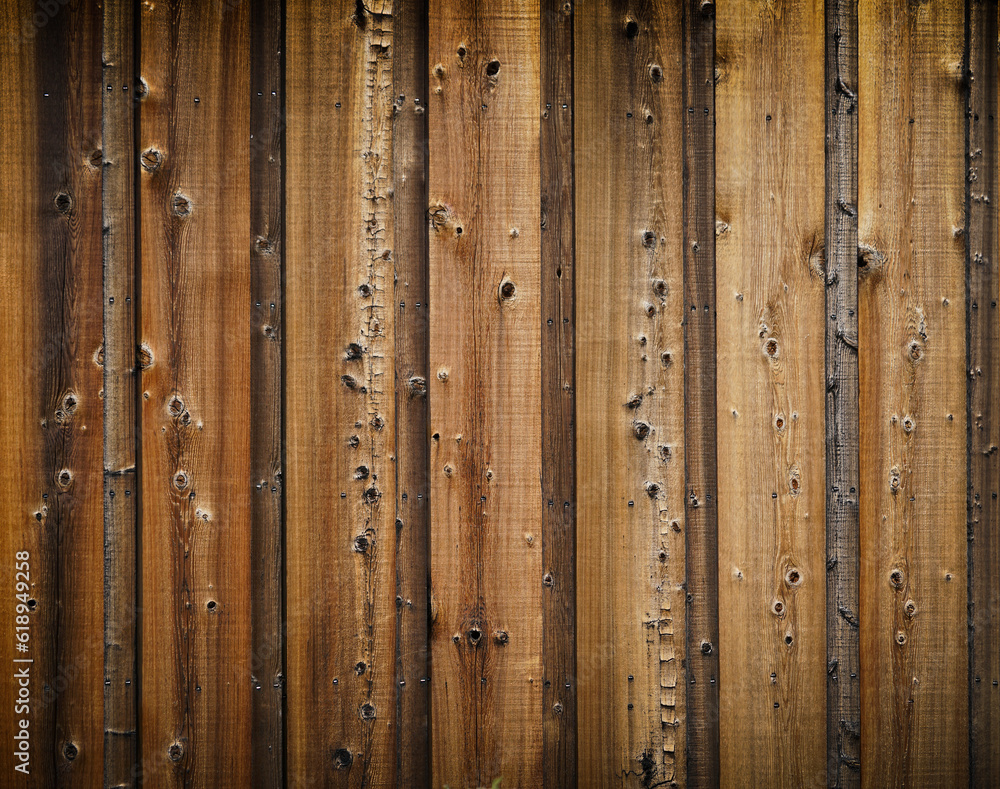 Dark stained reclaimed wood surface with aged boards lined up. Wooden