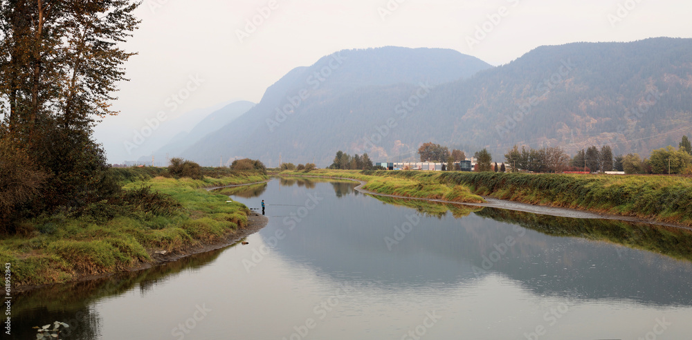 Obraz premium Fishing from river shore in a foggy morning
