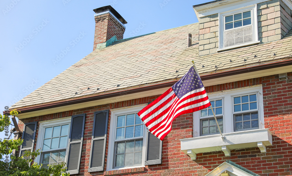 US flag waves proudly in front of an American home, representing the ...