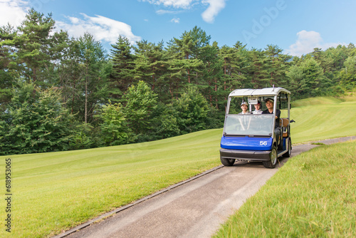 ゴルフ場でゴルフカートに乗るゴルファーの男女 
