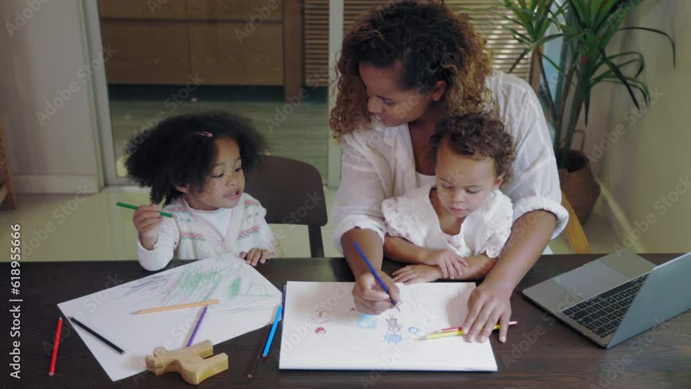 African mother multitasking painting with child while work from home African mother multitasking painting with child while work from home