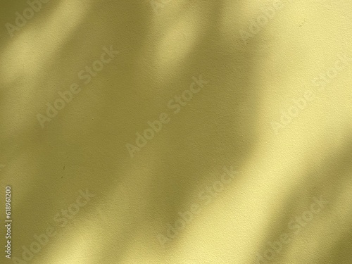 Yellow wall background with blurred circles light from the sun through tree branches. Copy space for your text.