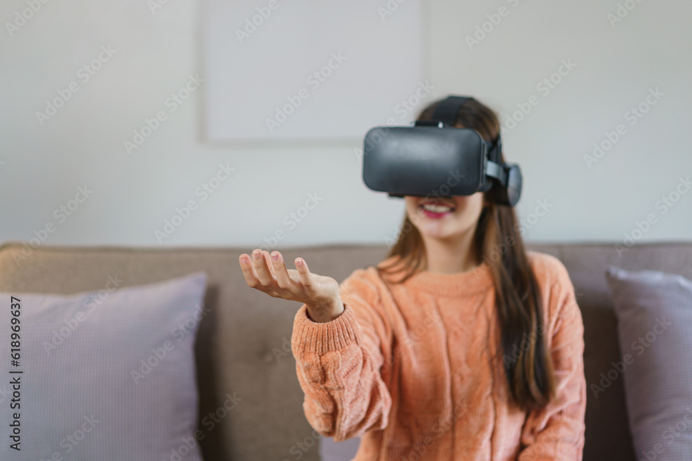 Women holding something and enjoying experience with virtual reality goggles to watch future world Women holding something and enjoying experience with virtual reality goggles to watch future world