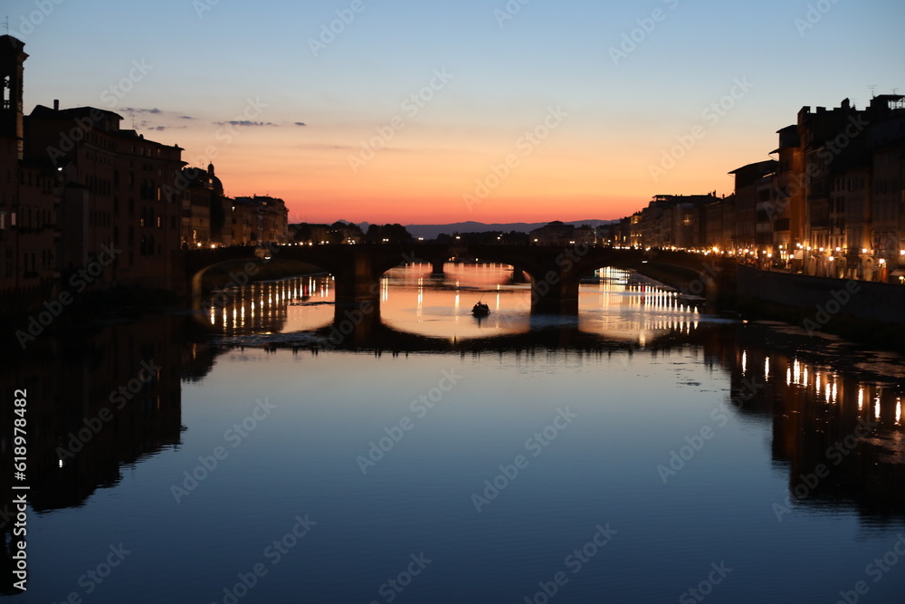 Sunset over the River Arno in the summer. Beautiful Ponte Vecchio city. Night view of the old town country. Dusk over the medieval city. Natural beauty in the evening.