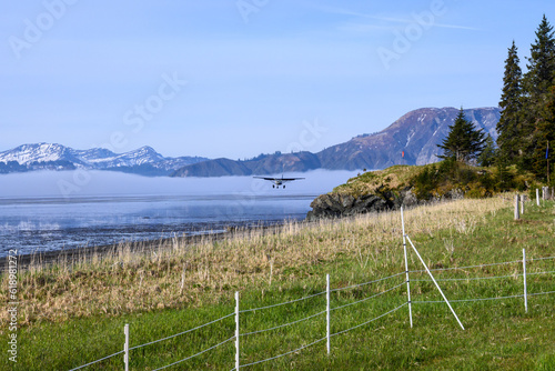 Small plane flying in for a landing on the beach of Chinitna Bay in Lake Clark National Park, ecotourism in Alaska
