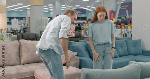 Customers woman and man buying new furniture. couple checking quality of sofa in a store. Furniture shop Family choosing new furniture for new modern house. Furnishings store.