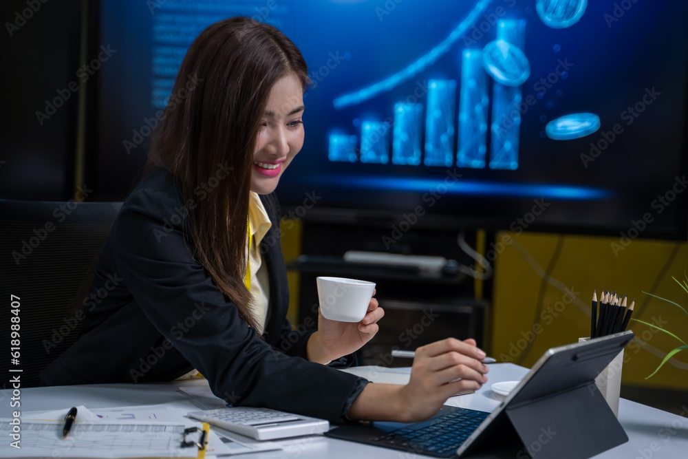 Asian businesswoman sitting there working with laptop Jot down paperwork and smile happily at work. Asian businesswoman sitting there working with laptop Jot down paperwork and smile happily at work.
