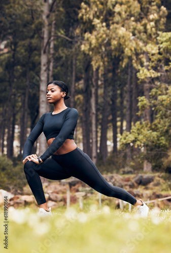 Stretching, fitness and black woman lunge in nature for exercise, training and sports in forest. Hiking, mountain and female person stretch legs for warm up, workout and wellness for performance