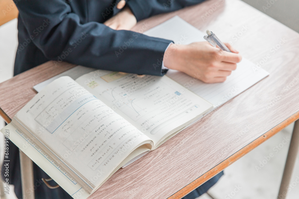 学校の教室で数学の教科書・参考書を見ながら勉強する女子高校生・中学生の生徒
学校の教室で数学の教科書・参考書を見ながら勉強する女子高校生・中学生の生徒