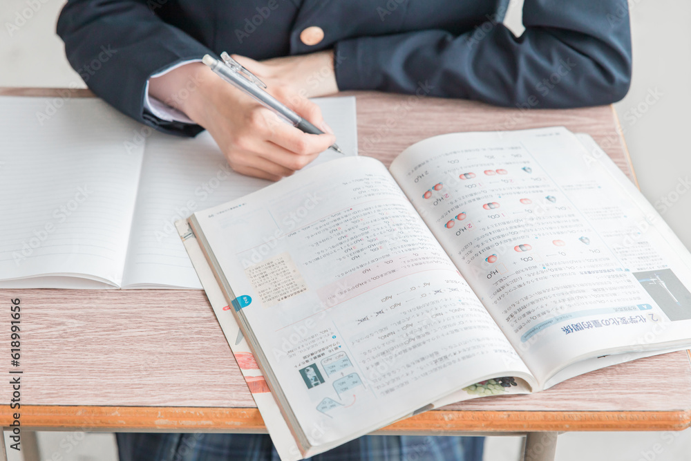 学校の教室で化学の教科書・参考書を見ながら勉強する女子高校生・中学生の生徒
学校の教室で化学の教科書・参考書を見ながら勉強する女子高校生・中学生の生徒
