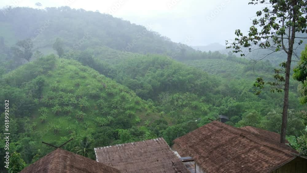 Raining over wooden cabin, a rural village in the mountains and forest, Northern Thailand Raining over wooden cabin, a rural village in the mountains and forest, Northern Thailand