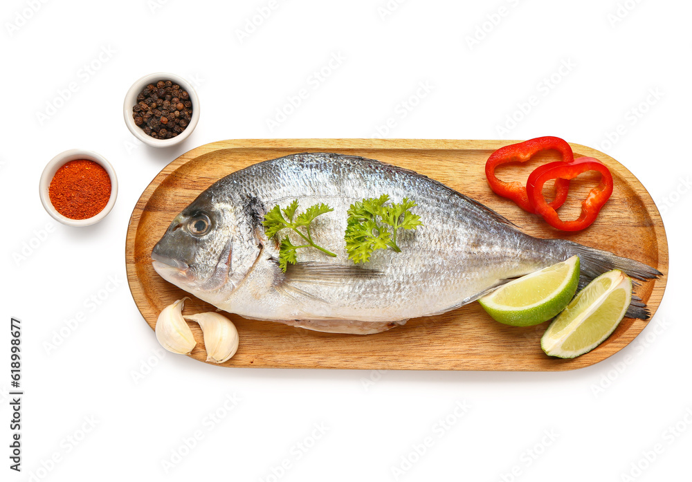 Wooden board of raw dorado fish with spices and lime on white background Wooden board of raw dorado fish with spices and lime on white background