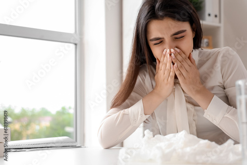 Sick woman with runny nose in office photo
