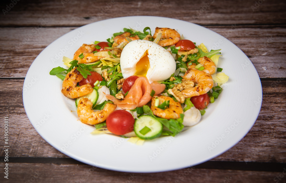 Recipe for rocket salad, endive, tomato, cucumber, soft-boiled egg, fried shrimp with paprika, smoked salmon and nuts. High quality photo Recipe for rocket salad, endive, tomato, cucumber, soft-boiled egg, fried shrimp with paprika, smoked salmon and nuts. High quality photo