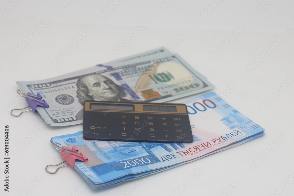 Dollars, calculator and paper clip on a white background. Dollars, calculator and paper clip on a white background.