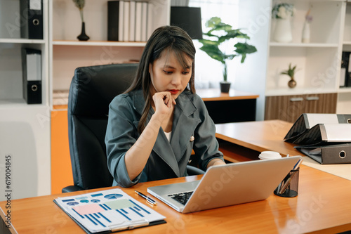 Business woman using tablet and laptop for doing math finance on an office desk, tax, report, accounting, statistics, and analytical research concept in office.