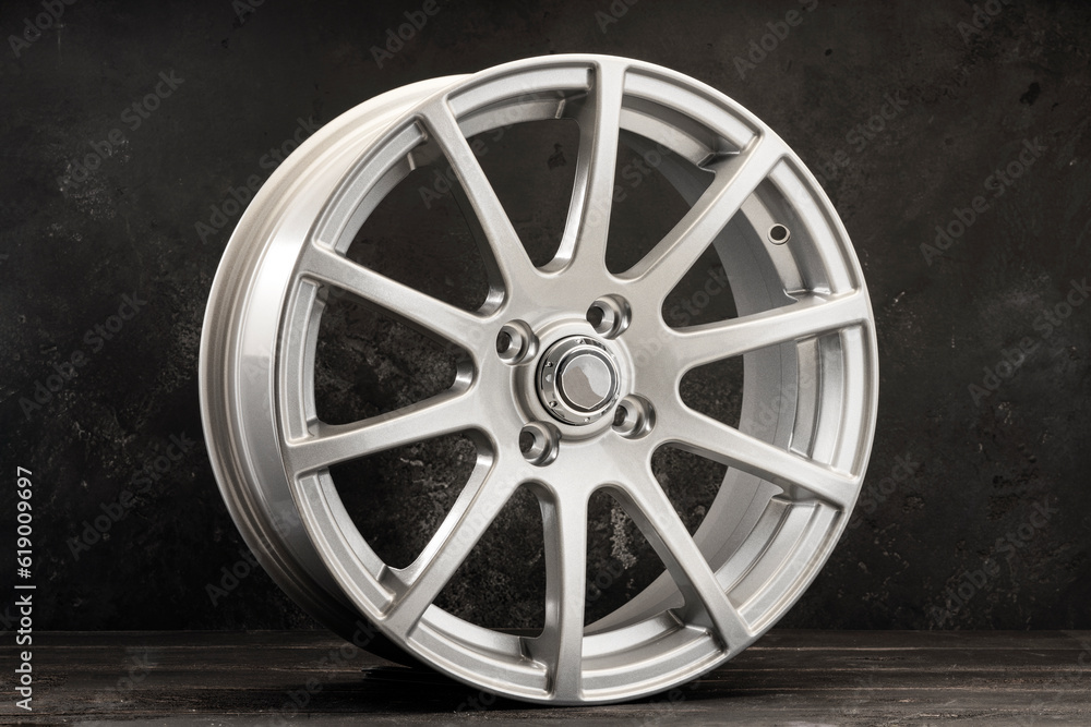 silver alloy wheels lightweight auto parts with many spokes on a dark textured background