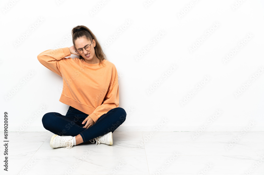 Young woman sitting on the floor with neckache Young woman sitting on the floor with neckache