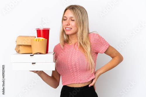 Young caucasian woman holding fat food isolated on blue background suffering from backache for having made an effort