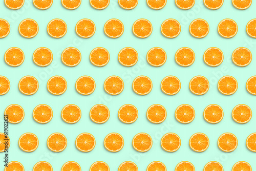 Orange fruit slices in horizontal rows isolated seamless pattern on light green background, top view