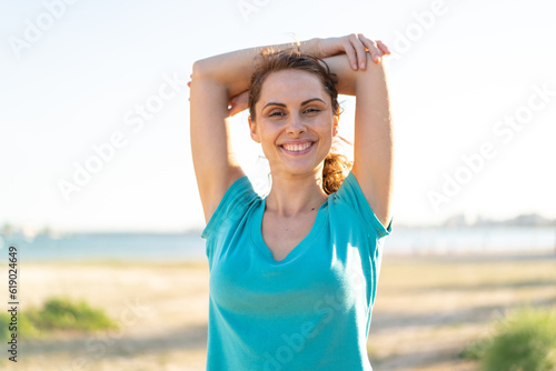 Young woman at outdoors doing sport and stretching