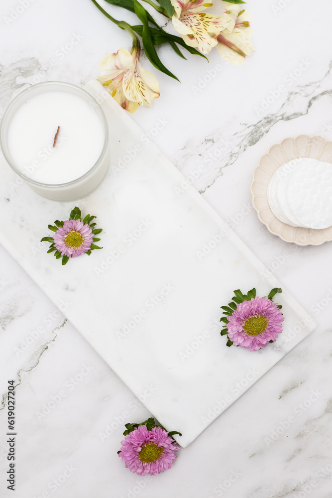 Flatlay of Flowers, Candles, Skincare, Cotton Pads, Aesthetic Dishes and Trays on Marble Table