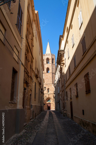 Old street with church tower and stone houses in Alghero city on Sardinia island  Italy.