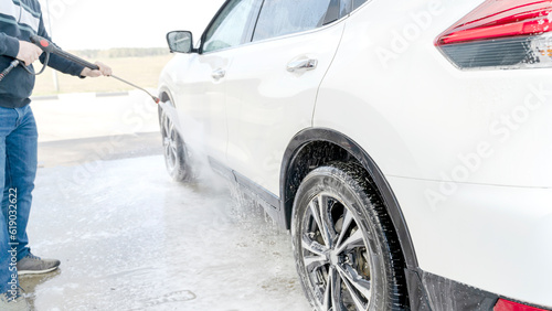 a man washes a car at a self-service car wash
