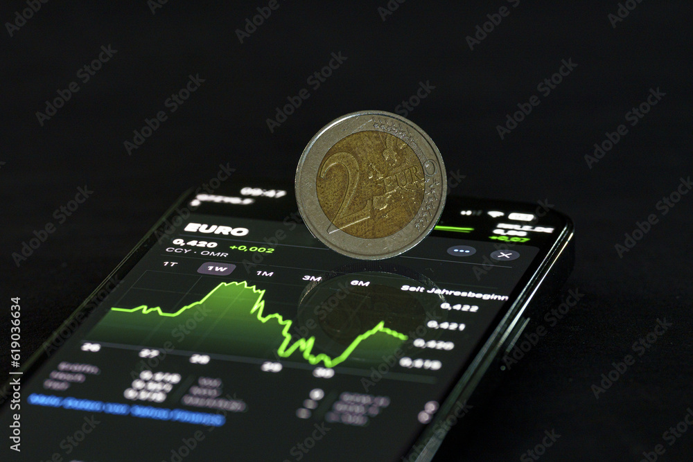 Close up of cell phone with glowing euro on dark background, with sample square. Online banking and finance concept, digital euro Close up of cell phone with glowing euro on dark background, with sample square. Online banking and finance concept, digital euro