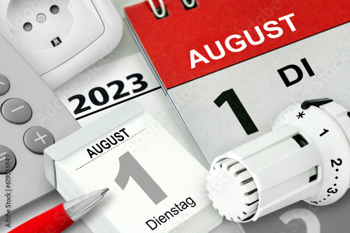 Konzept für Energie und Deutscher Kalender Datum 1. August 2023 Heizungsthermostat und Rechner mit Steckdose