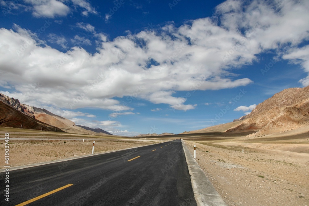 Aerial view of road through desert surrounded by hills