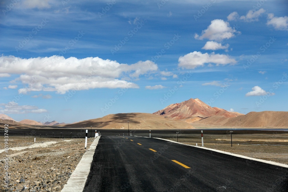 Aerial view of road through desert surrounded by hills