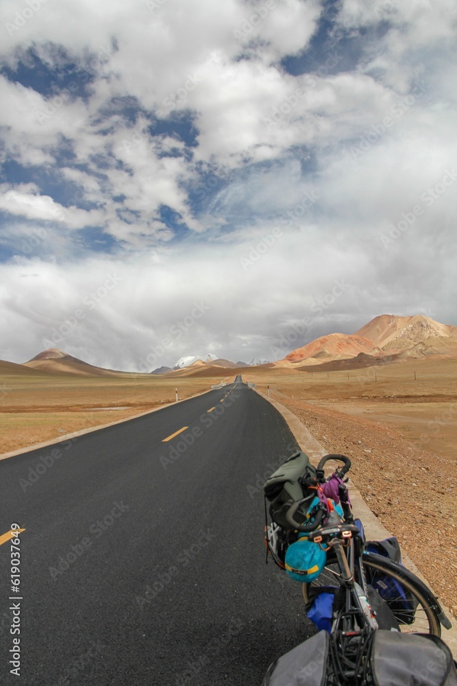Bike on road through desert surrounded by mountains Bike on road through desert surrounded by mountains