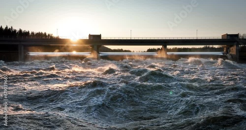 Wallpaper Mural Beautiful view of water waves splashing under a silhouette bridge and trees at dusk time Torontodigital.ca