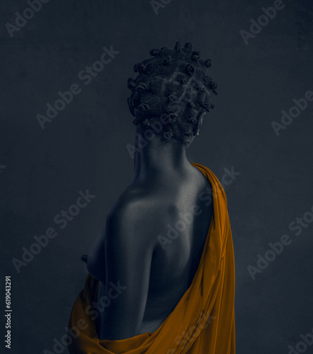 A CLASSICAL FINE ART PORTRAIT OF A MYSTERIOUS BLACK WOMAN FACING AWAY WITH FABRICS DELICATELY DRAPED IN HER SHOULDER. photo