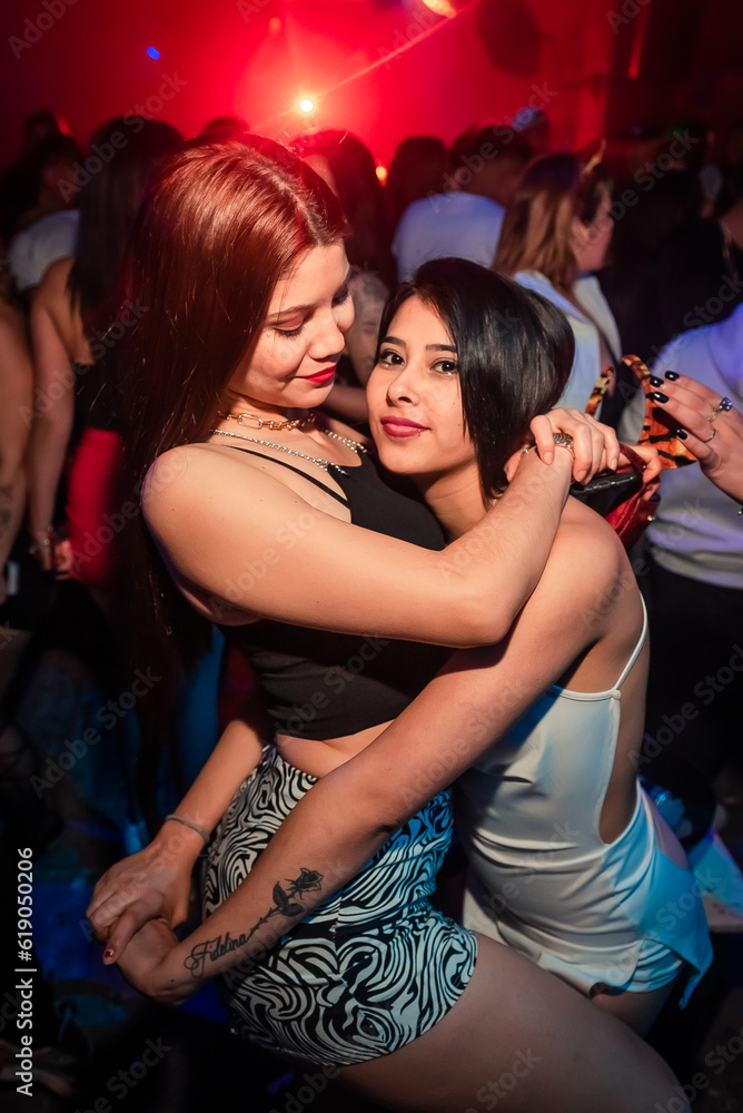 some beautiful girls dancing and posing for a photo at a party. Young people dancing at night club party. selective focus. Long exposition. Moving lights. party concept. Party night club. Nightclub some beautiful girls dancing and posing for a photo at a party. Young people dancing at night club party. selective focus. Long exposition. Moving lights. party concept. Party night club. Nightclub