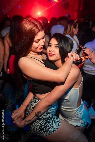 some beautiful girls dancing and posing for a photo at a party. Young people dancing at night club party. selective focus. Long exposition. Moving lights. party concept. Party night club. Nightclub