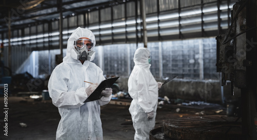 Workers wear protection suit checking chemical in old factory. Protecting Against Hazards and Contamination. Emergency Response to a Radioactive Accident.
