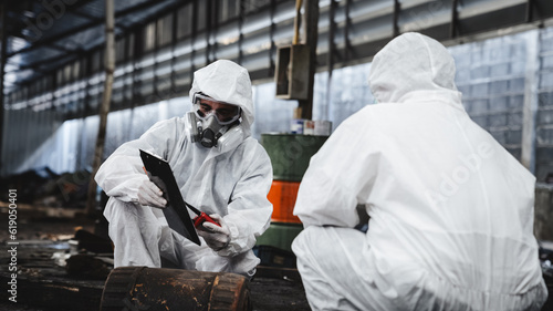 Workers wear protection suit checking chemical in old factory. Protecting Against Hazards and Contamination. Emergency Response to a Radioactive Accident. © NewSaetiew