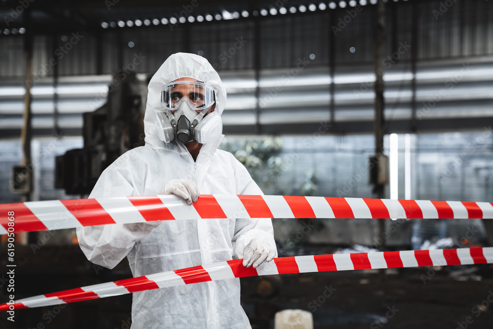 Fototapeta premium Workers wear protection suit checking chemical contaminated oil in old factory. Red and White Lines Marking a Dangerous Zone. Biohazard Contamination Control.