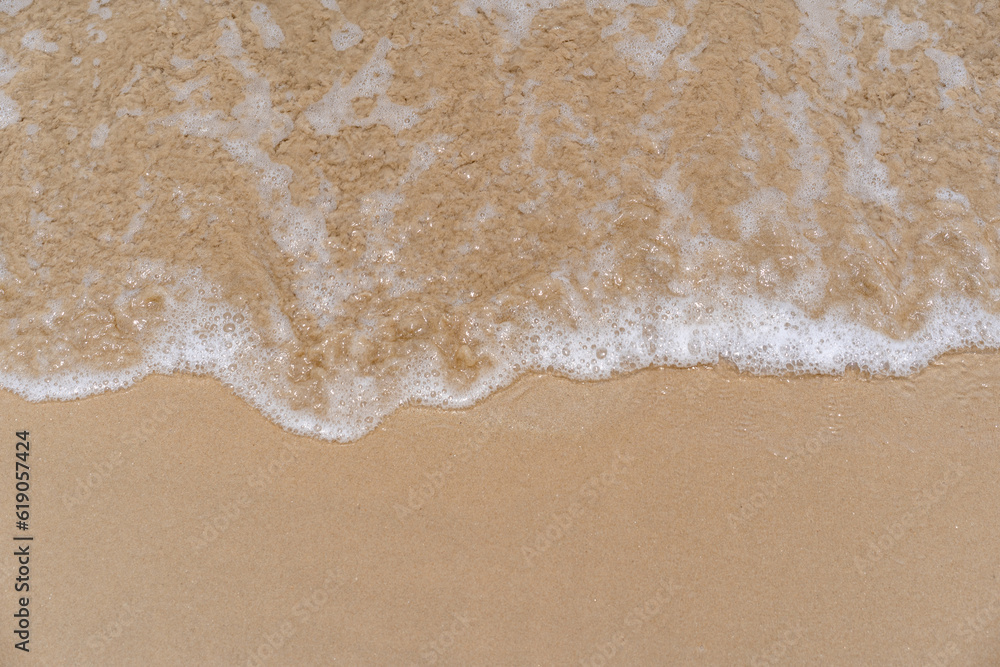 closed up of sea wave with white foam and softness sand background textured on a sunny day, clean and empty beach for outdoor summer activity closed up of sea wave with white foam and softness sand background textured on a sunny day, clean and empty beach for outdoor summer activity