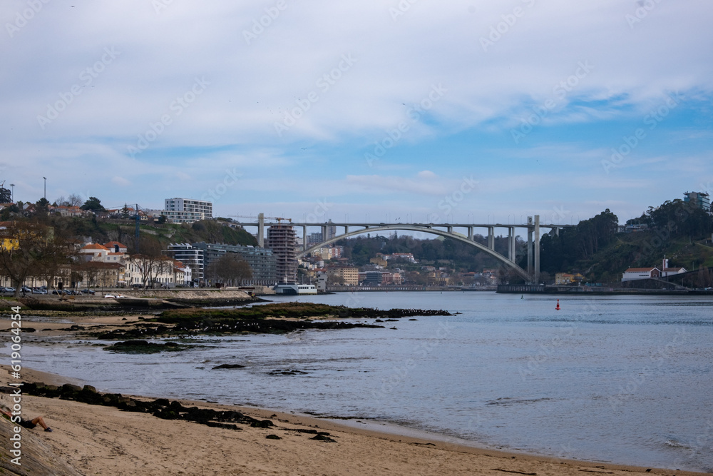 la belleza de Oporto, Portugal, con el emblemático puente de Don Luis como protagonista. En la imagen, el puente de hierro se extiende majestuosamente sobre el río Duero, conectando las dos orillas.