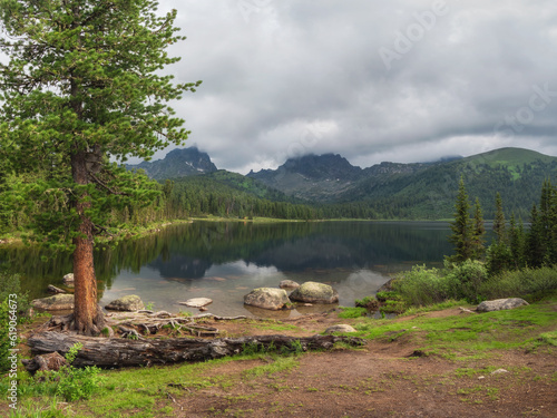 Lake Svetloye in Ergaki on an summer morning among the taiga rocks with blue sky in the warm sun and trees Mountain sunny landscape. Ergaki Nature Park in the mountains of Siberia. Western Sayan. photo