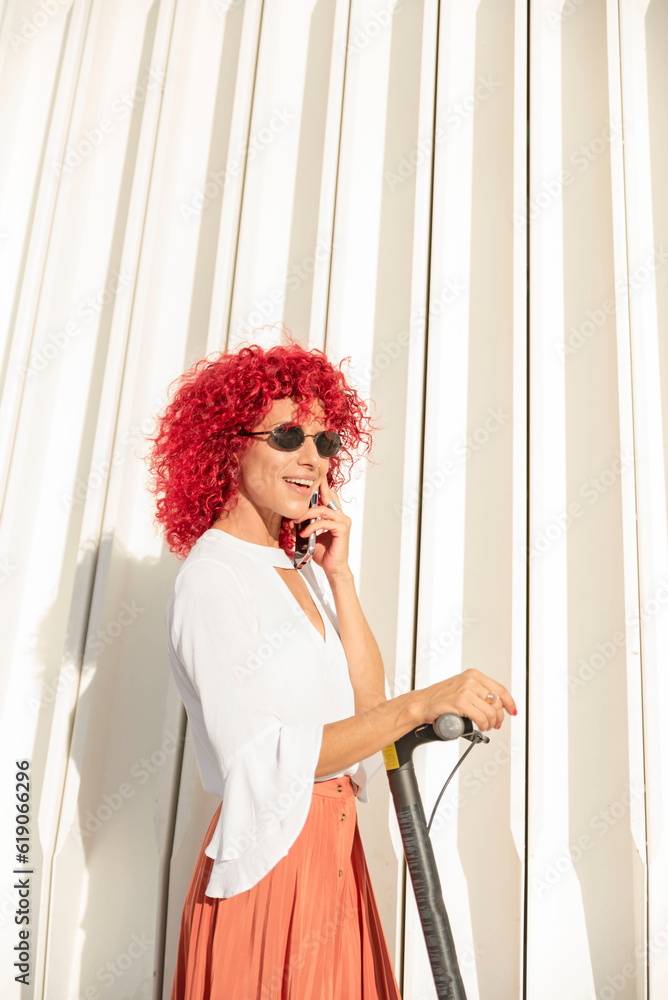 Φωτογραφία vertical portrait of an elegant woman with red afro hair and sunglasses talking